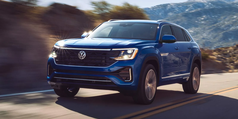 Blue Volkswagen SUV driving on a mountain road.