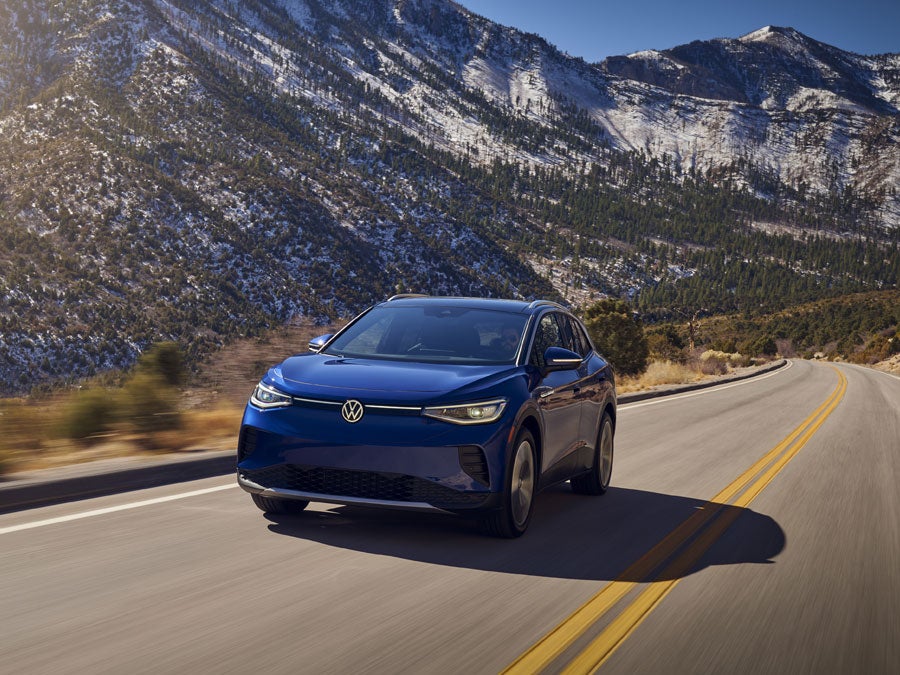 Volkswagen ID.4 electric SUV driving near Zilker Park in Austin TX with skyline in background
