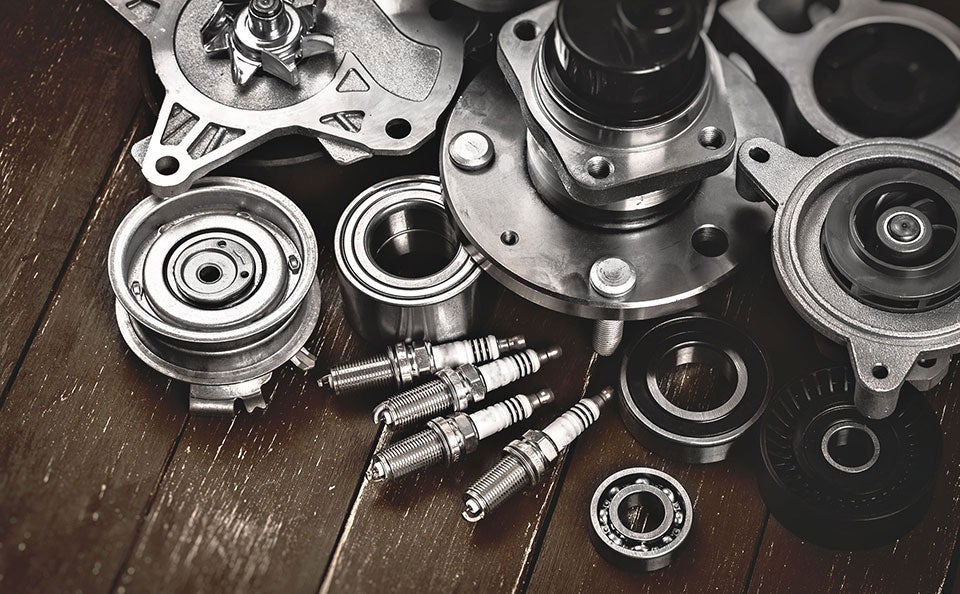 Engine parts and spark plugs on workbench.